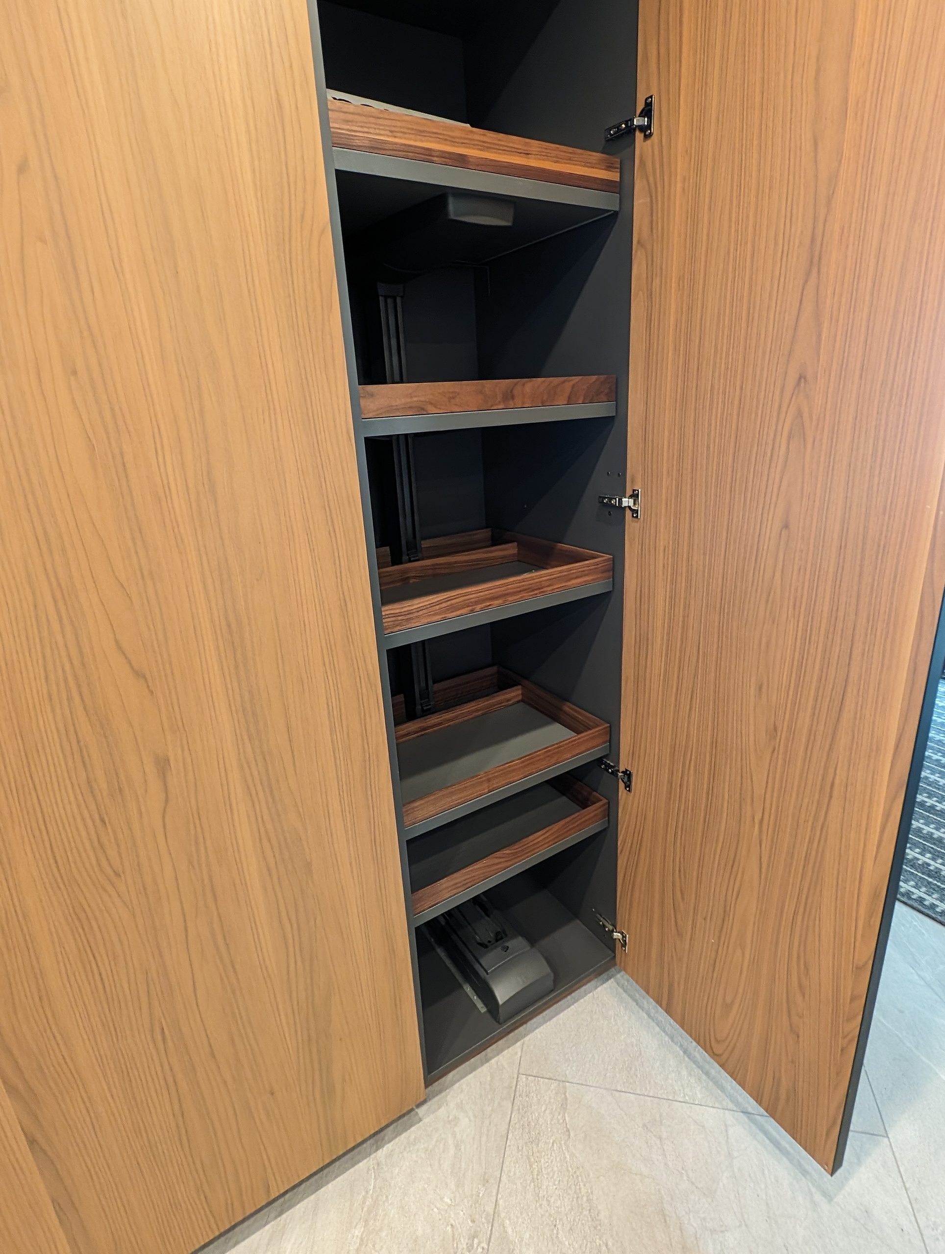 Full-height pantry unit opened to reveal internal pull-out shelves
