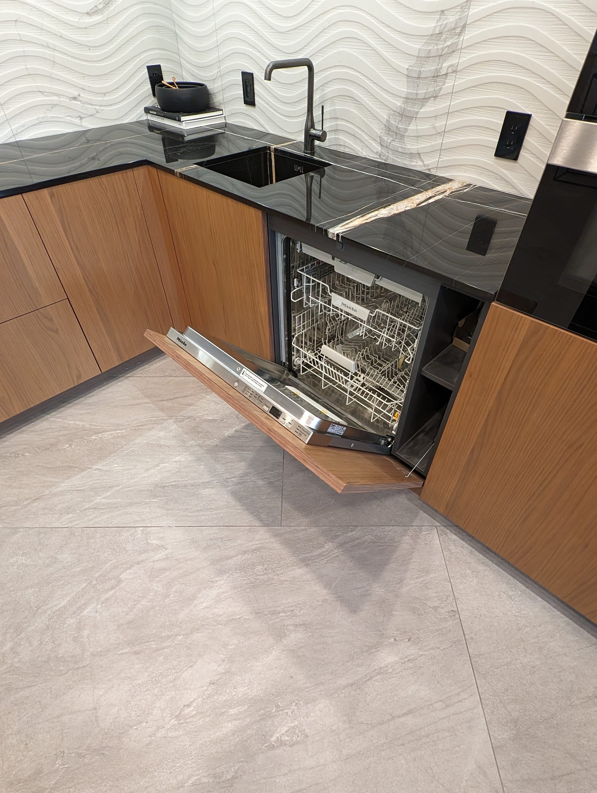 Fully integrated dishwasher behind a matching walnut front in the prep kitchen
