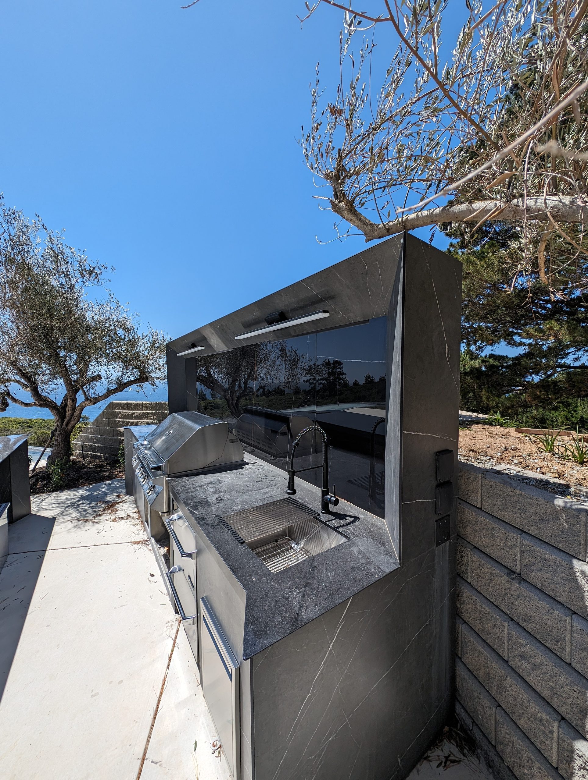 Outdoor kitchen detail — grill and integrated sink under the hood