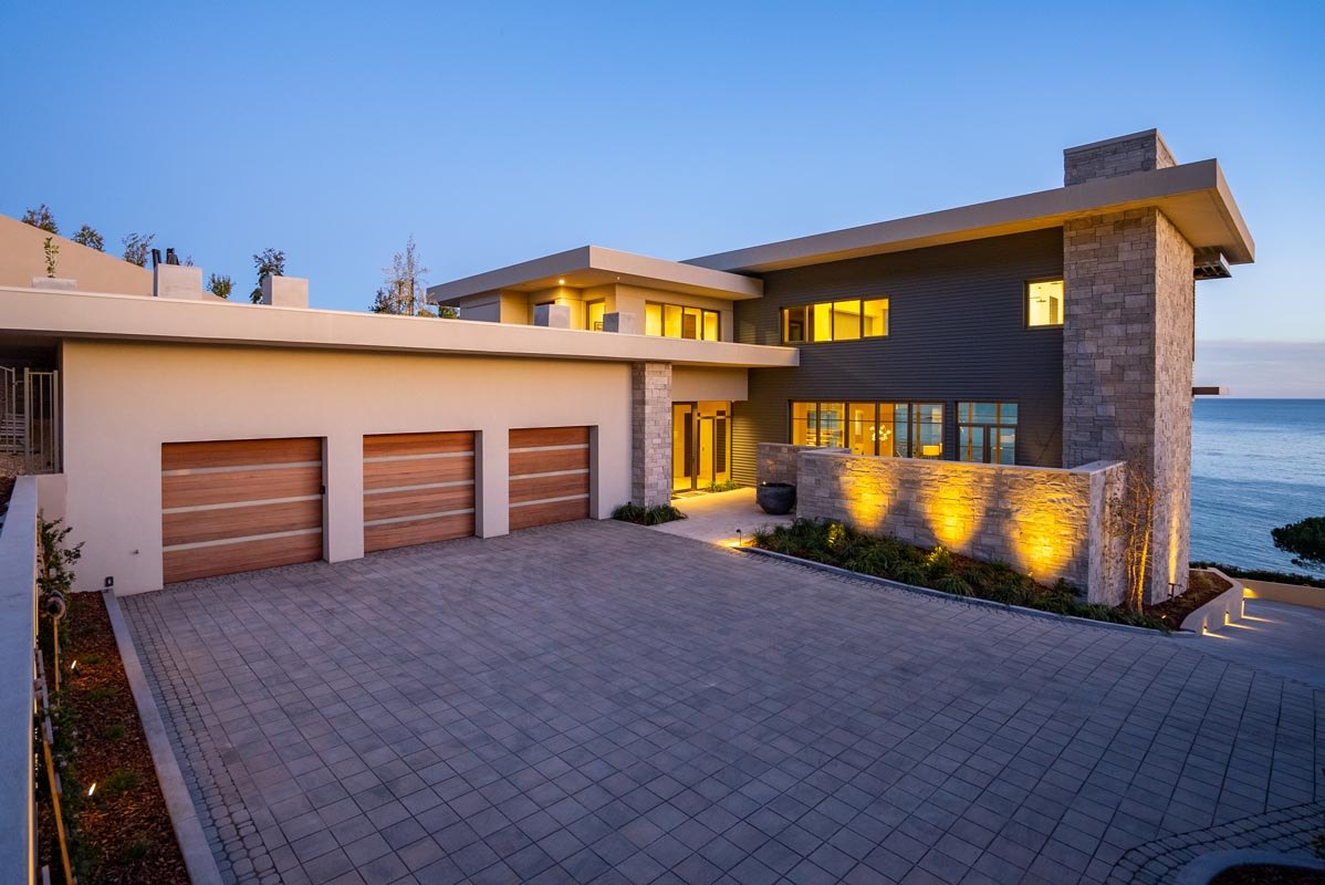 Motor court and garages at dusk, warm light on the paving