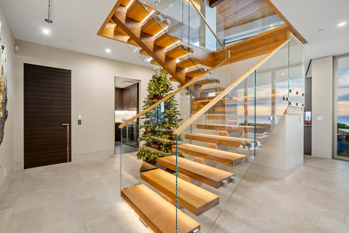 The oak stair climbing all three storeys of the glass shaft