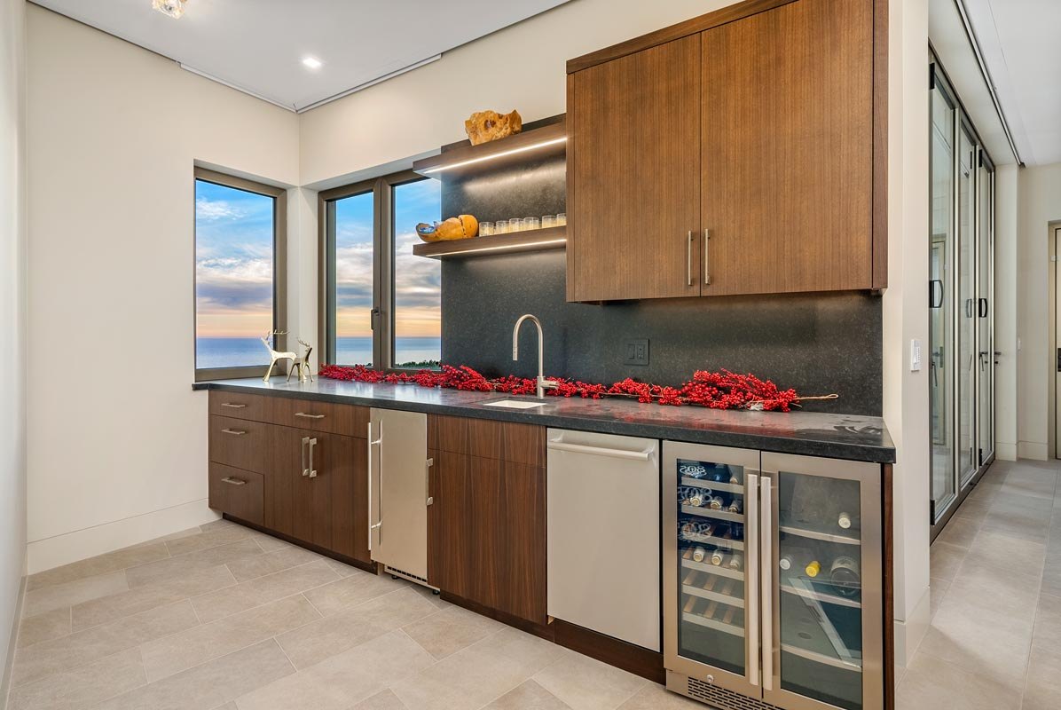 Butler's pantry — dark stone counter and splash, wine fridge below