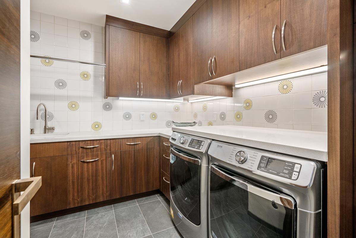 Laundry in walnut with full-height storage and patterned tile splash
